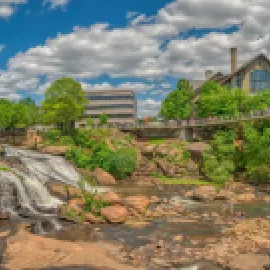 Photo of Reedy Falls and Liberty Bridge with Grand Bohemian Lodge Greenville in the background.