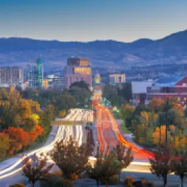 Photo of downtown Boise from a freeway with car lights.