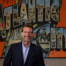 Gary Musich stands in front of Atlantic City mural