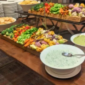 Photo of a serving table with a large selection of vegetables and dips.