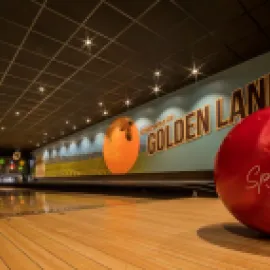 Photo of a red bowling ball in a bowling alley.