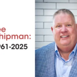 Photo of Lee Chipman in a blue blazer in front of a white brick background