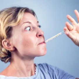 Image of a woman with a thermometer in her mouth.
