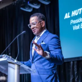 Photo of Al Hutchinson speaking on stage.