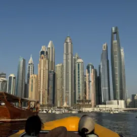 Photo of the skyline of Dubai from a boat on the water.
