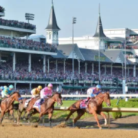 Photo of thoroughbred horses rounding at turn at Churchill Downs during the Kentucky Derby.
