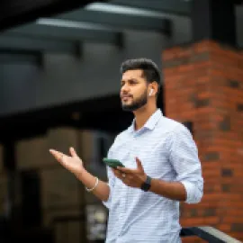 man wearing airpods and holding phone