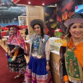 Peru booth at IMEX America 2025, with three women dressed in traditional Peruvian clothes.