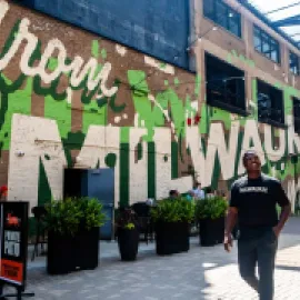 LeRoy Butler poses in front of a Milwaukee mural for Ask LeRoy. Credit: Visit Milwaukee