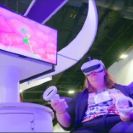 Photo of a woman wearing goggles to participate in a virtual reality activation.