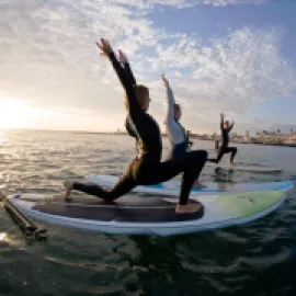 People doing stand-up yoga on paddleboards.