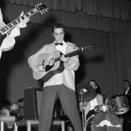 Elvis Presley performing on stage in the 1950s.