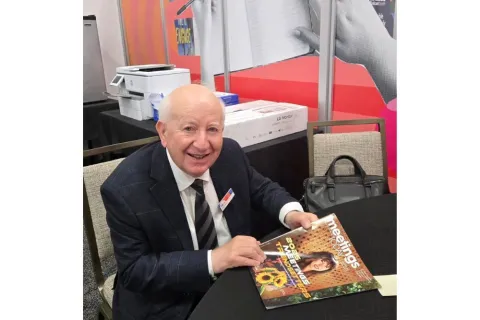 Ray Bloom holding Meetings Today magazine. 