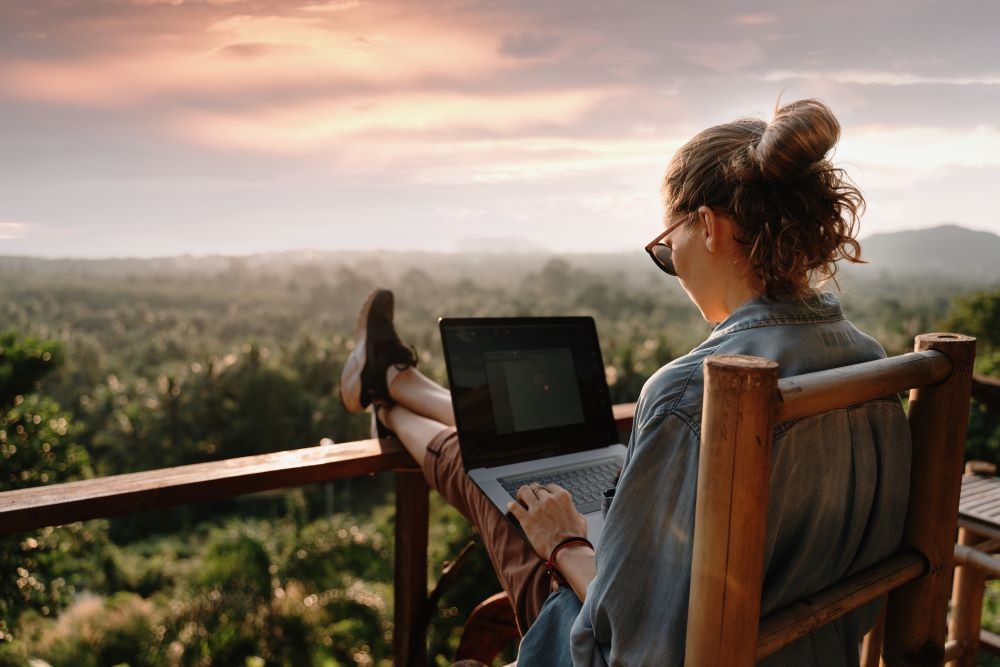 Photo of woman working on laptop outside