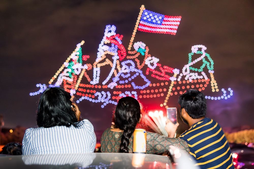 Family watches drone light show display on Fourth of July celebration