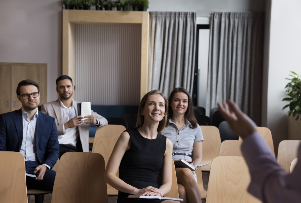 Group of people sitting in chairs listening to a speaker.