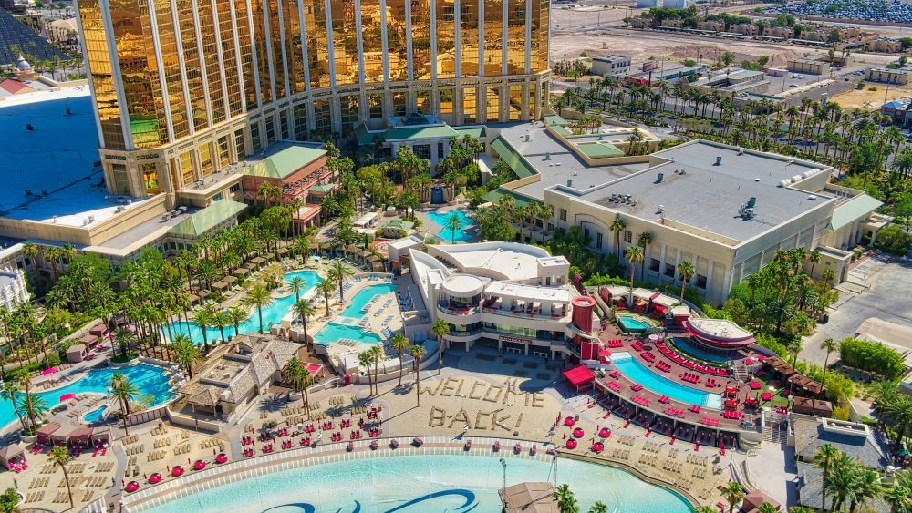 Aerial photo of Mandalay Bay Resort and Casino with the words "welcome back" in the sand on its beach.