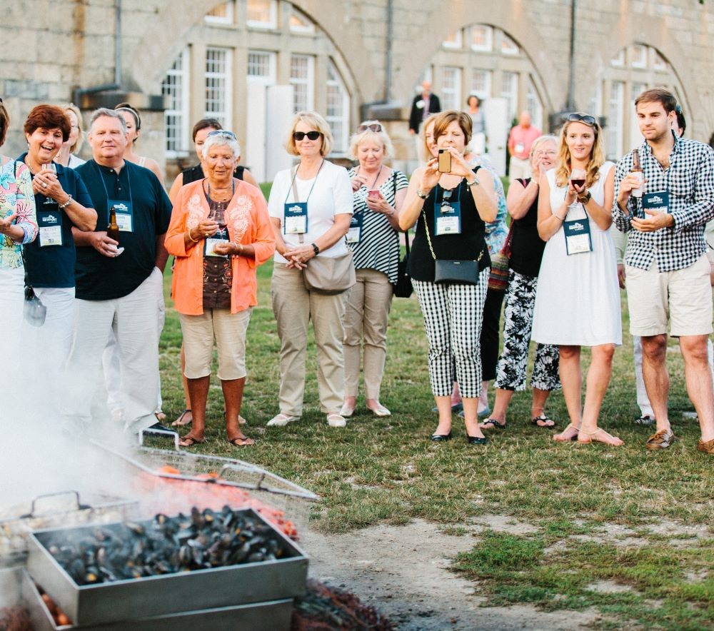 Group of attendees watching a clam bake at Fort Adams in Newport, Rhode Island