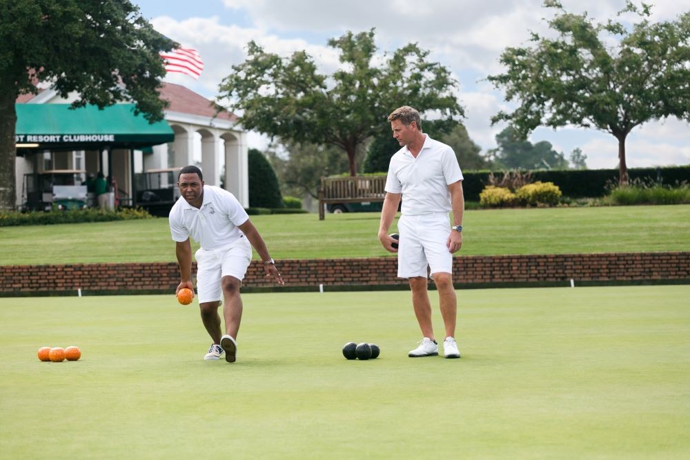 Image of two men lawnbowling at Pinehurst resort, in white shorts and teeshirts.