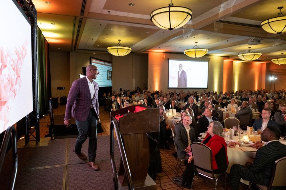 Meeting room full of attendees and a stage with a speaker in Lincoln, Nebraska