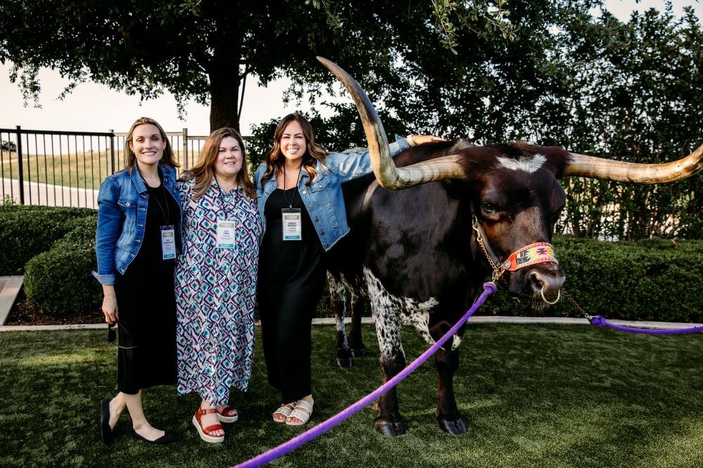 Attendees pose at Meetings Today LIVE! National next to bull in San Antonio