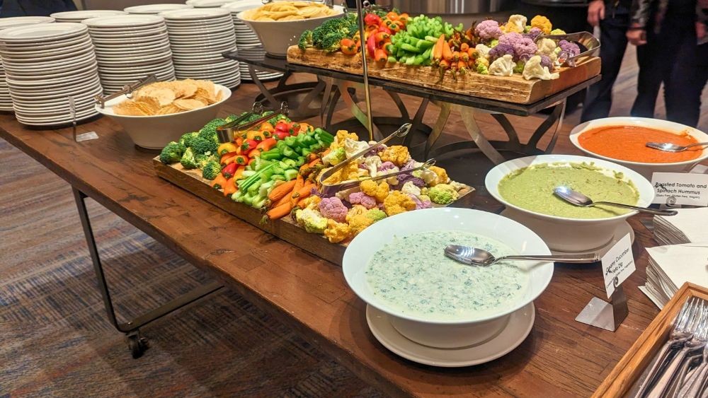 Photo of a serving table with a large selection of vegetables and dips.
