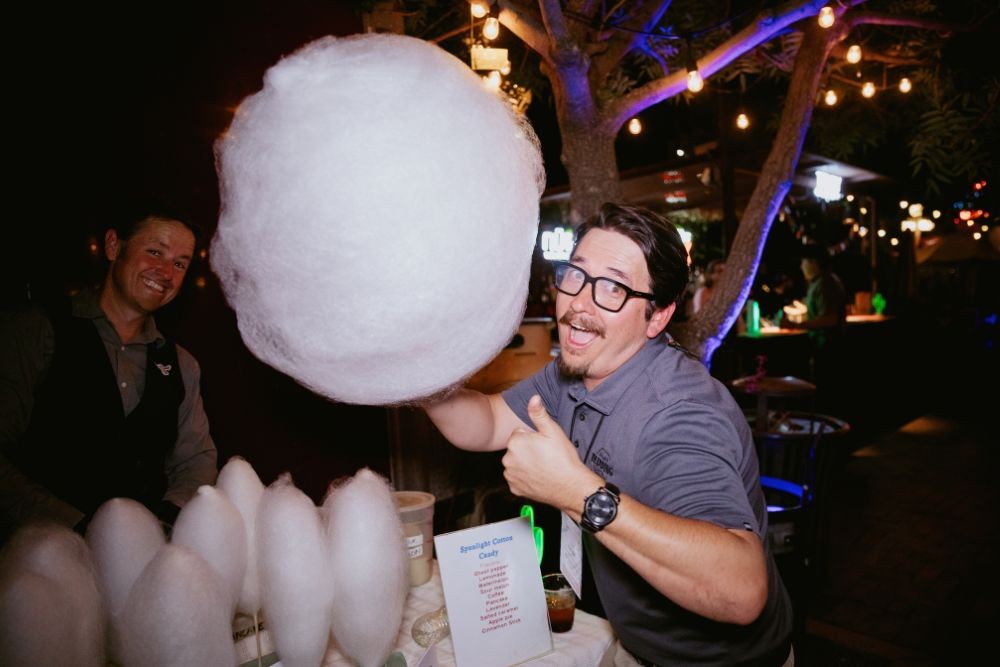 Attendee posing with giant cotton candy at Meetings Today LIVE! closing event. Credit: Wandering Maverick Photo+Film