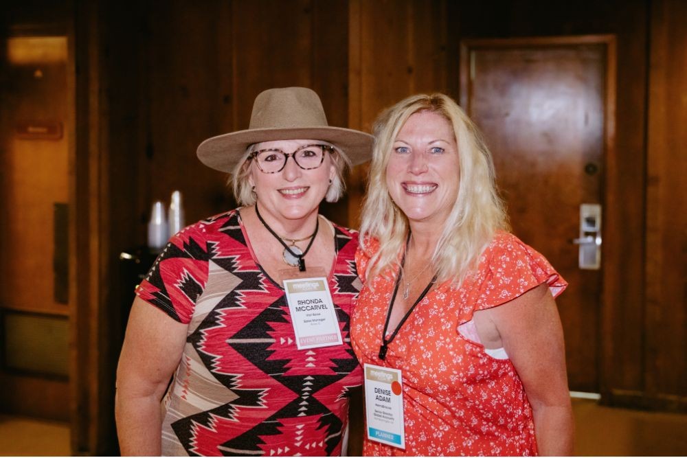 Two attendees smiling at opening reception. Credit: Wandering Maverick Photo+Film
