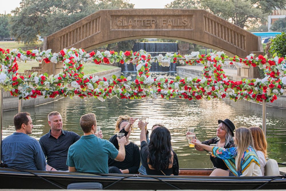A group of people on a gondola toasting each other on Lake Carolyn.