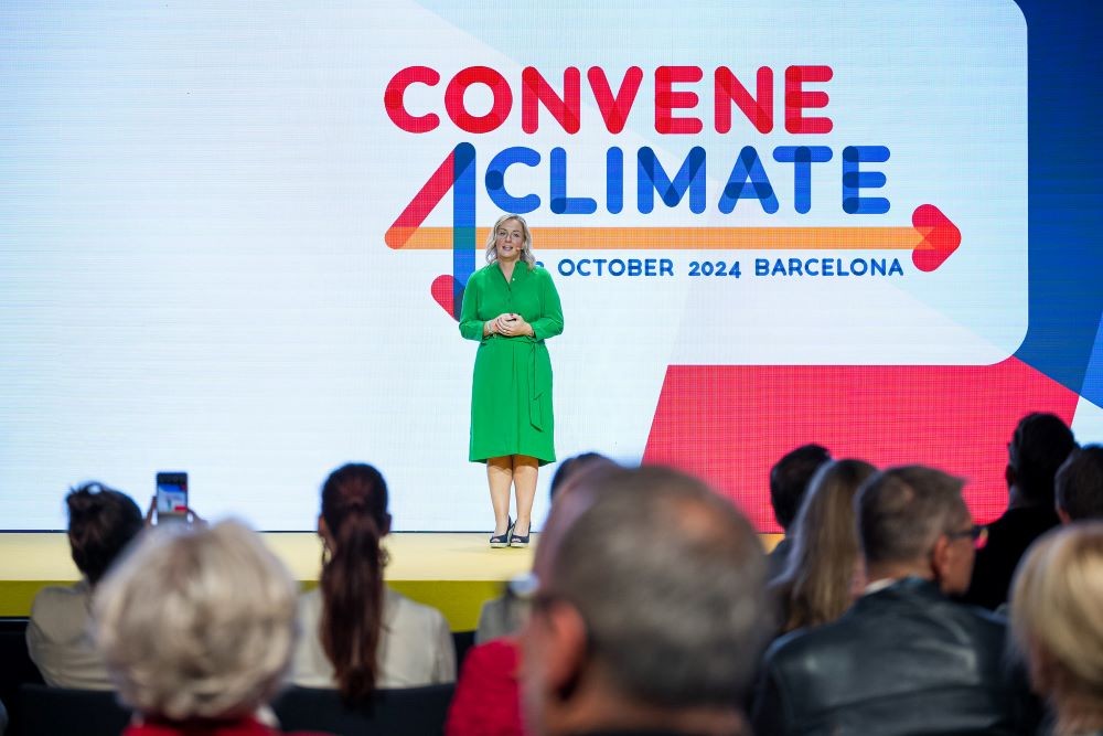 EMEA leader in green dress speaking on main stage