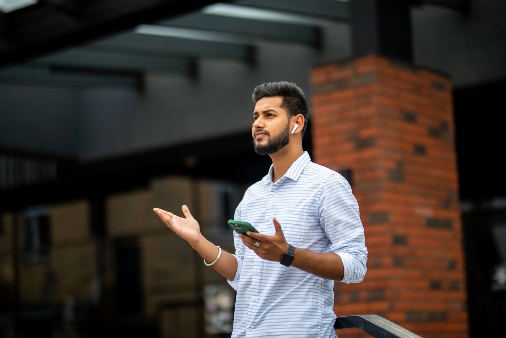 man wearing airpods and holding phone
