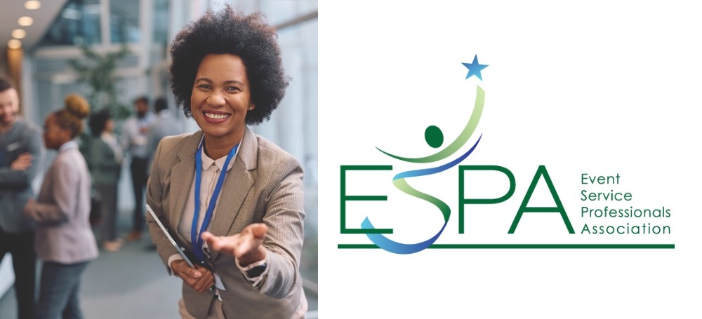 Image of a woman at a convention center with her hand outstretched to the viewer.