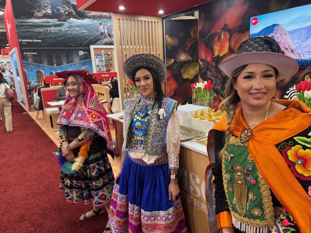 Peru booth at IMEX America 2025, with three women dressed in traditional Peruvian clothes.