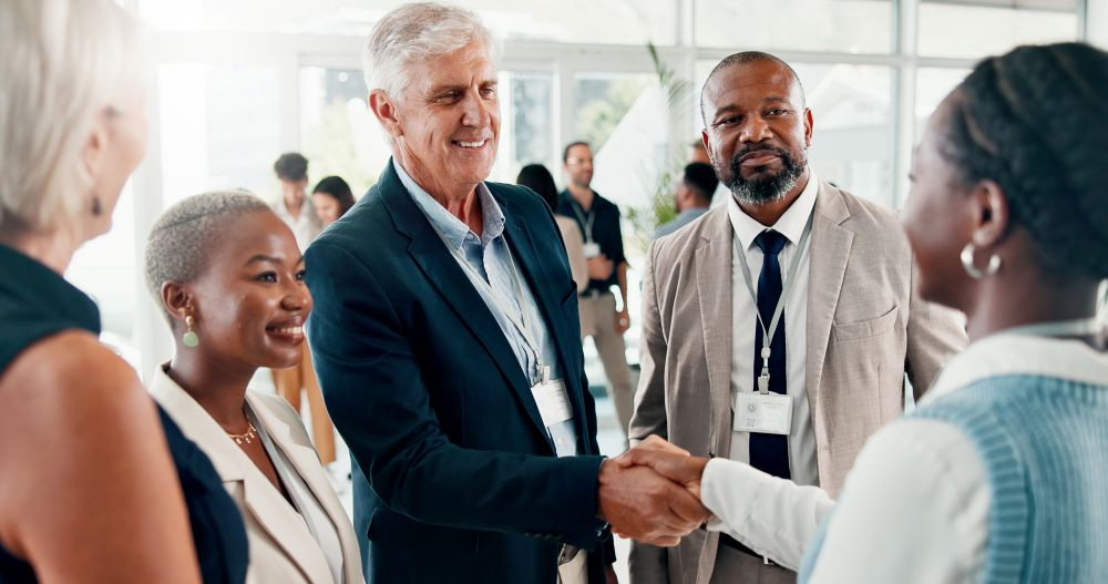 Photo of a person shaking another person's hand during a networking event.