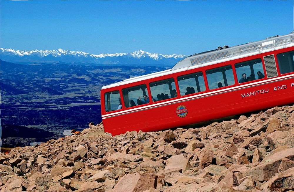 Pikes Peak Cog Railway train going up a mountain.