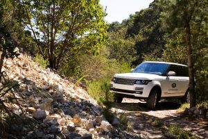 Photo of a white range rover navigating hilly terrain 